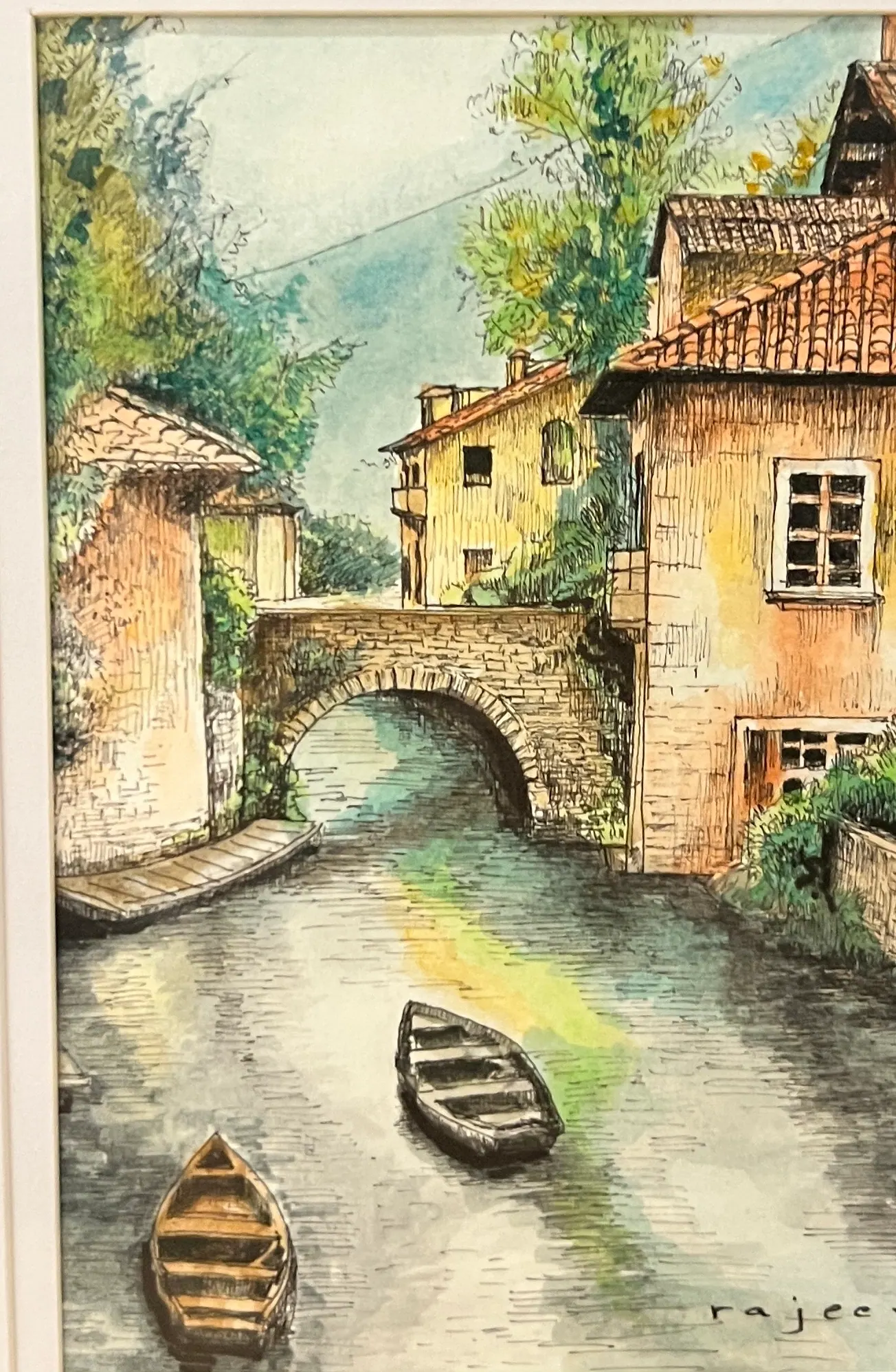 Pen and wash landscape of a canal with two rowing boats, a stone arch bridge and terracotta-roofed houses.